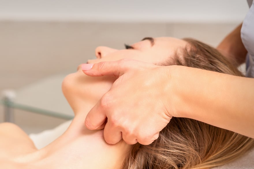 Beautician Making Lymphatic Drainage Face Massage or Facelifting Massage at the Beauty Salon.